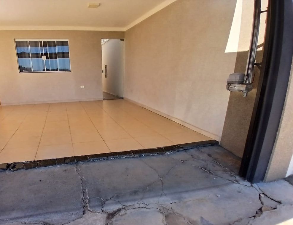 Área construída de imóvel residencial, com piso interno, esquadria e acesso de garagem.